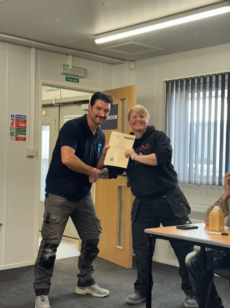 Receiving a certificate at the Building Heroes multi-skills course