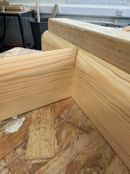 Close-up of a timber mitre joint cut and fitted during carpentry practice