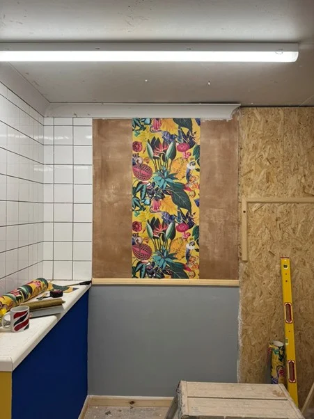Feature strip of colourful wallpaper hung on a training bay wall