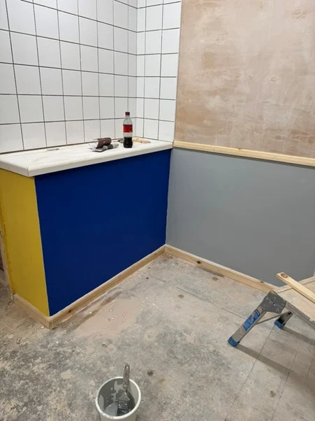 Painted training bay corner with tiled wall and timber trim